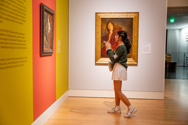 A woman viewing a painting at the Georgia Museum of Art